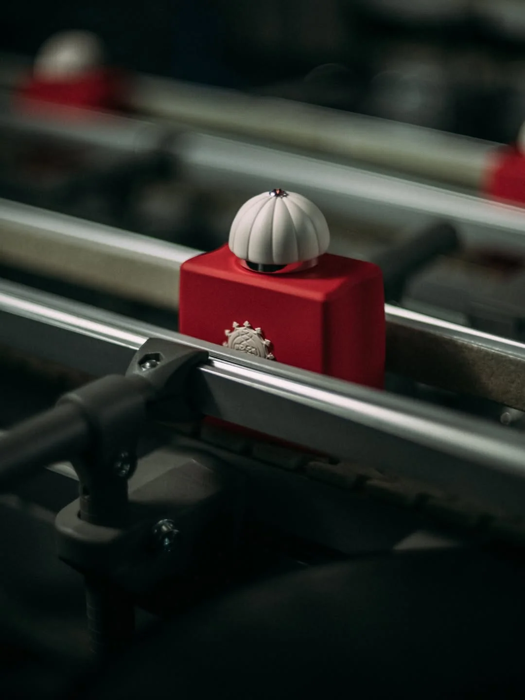 A red Amouage perfume bottle on a production conveyor