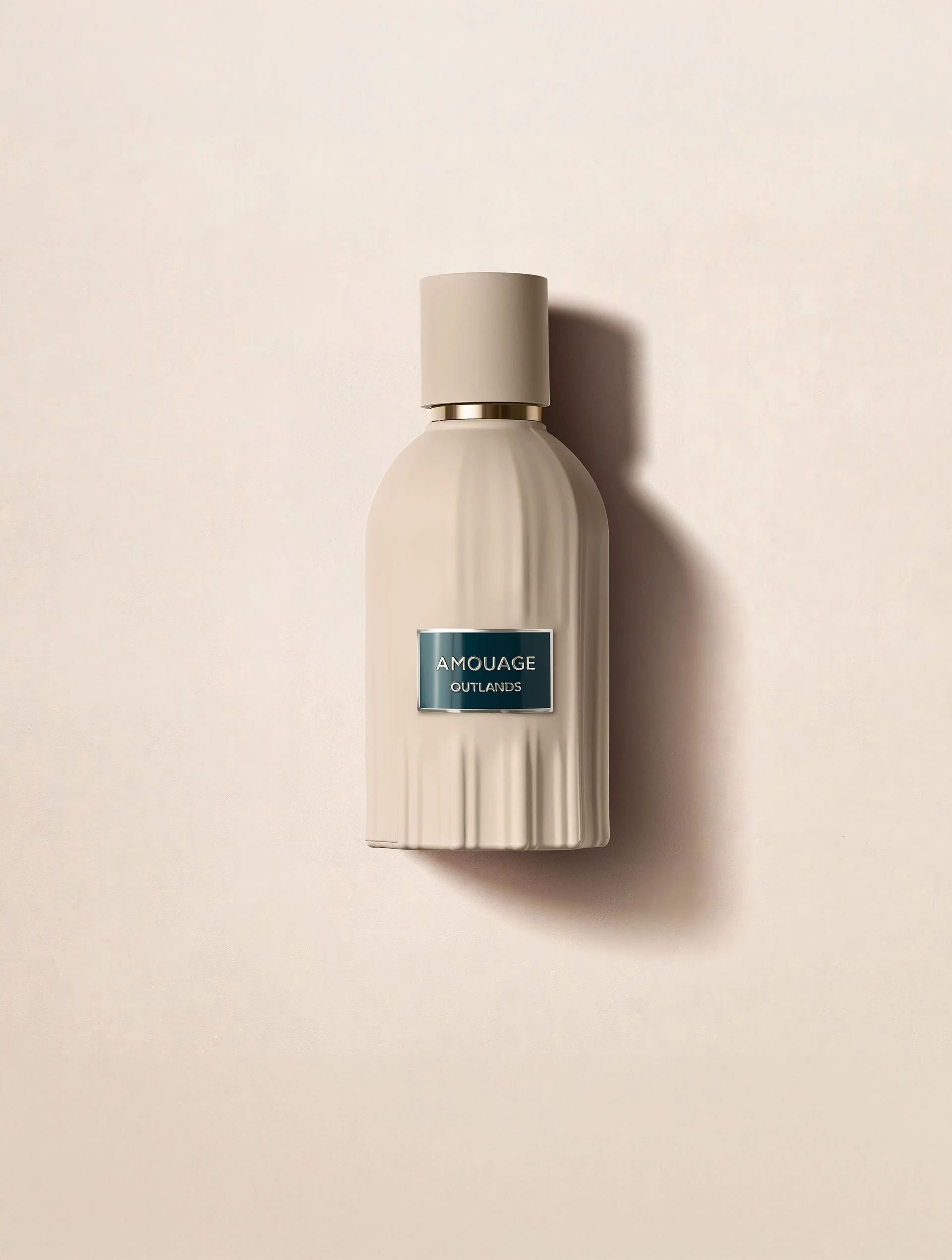 An ivory Amouage perfume bottle on a cream background