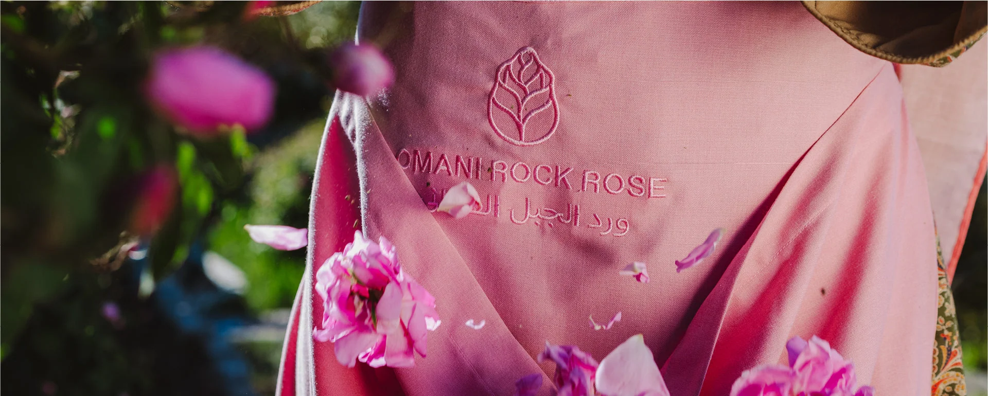 Pink Amouage Guidance packaging surrounded by roses